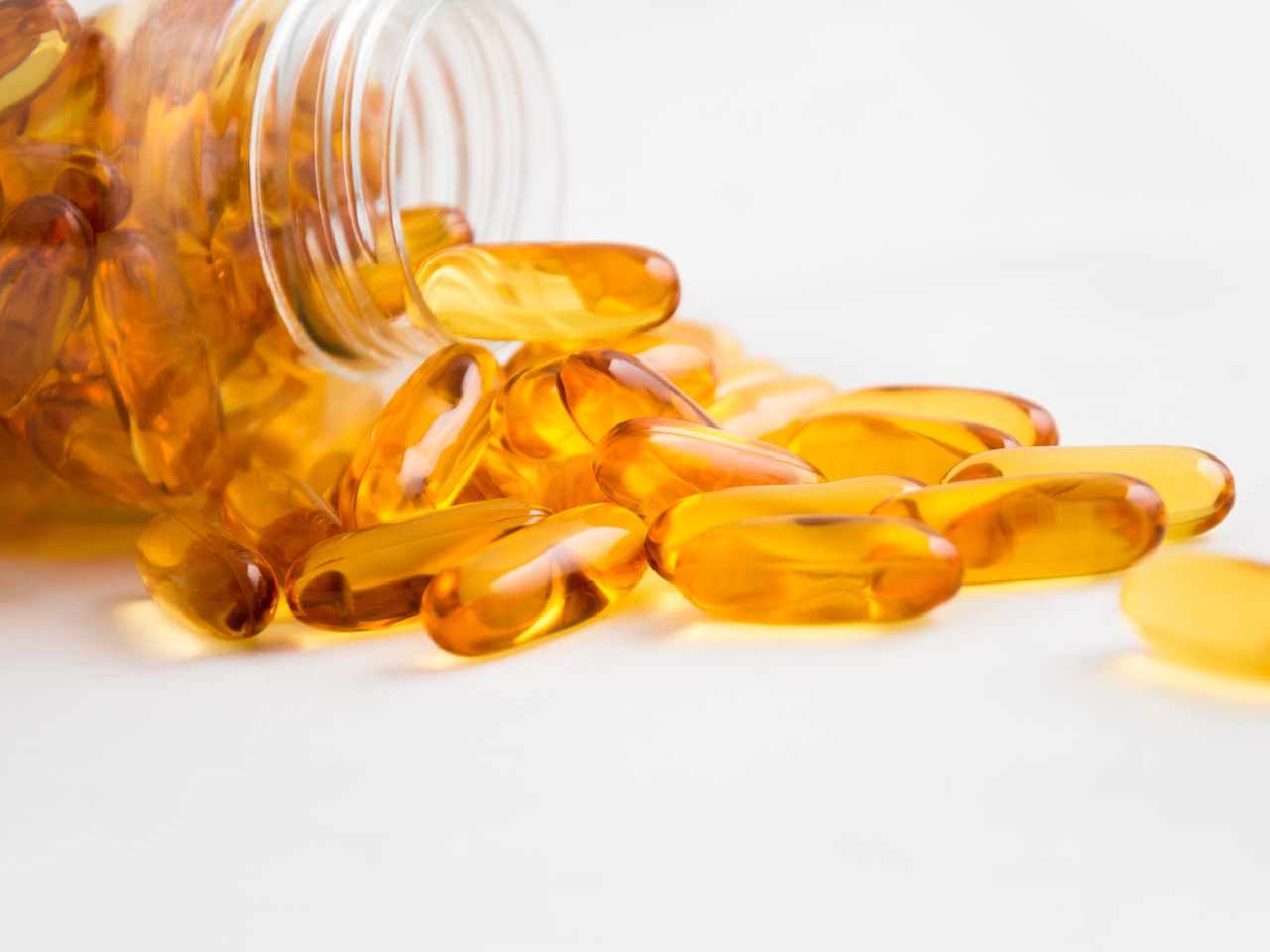 fish oil capsules spilling out of a jar out of the jar