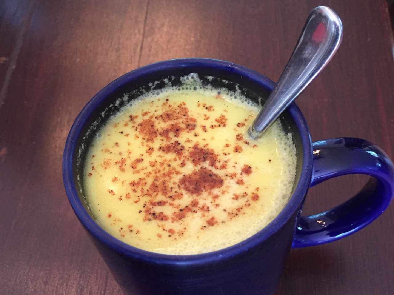 golden turmeric and ginger milk in a mug with cinnamon