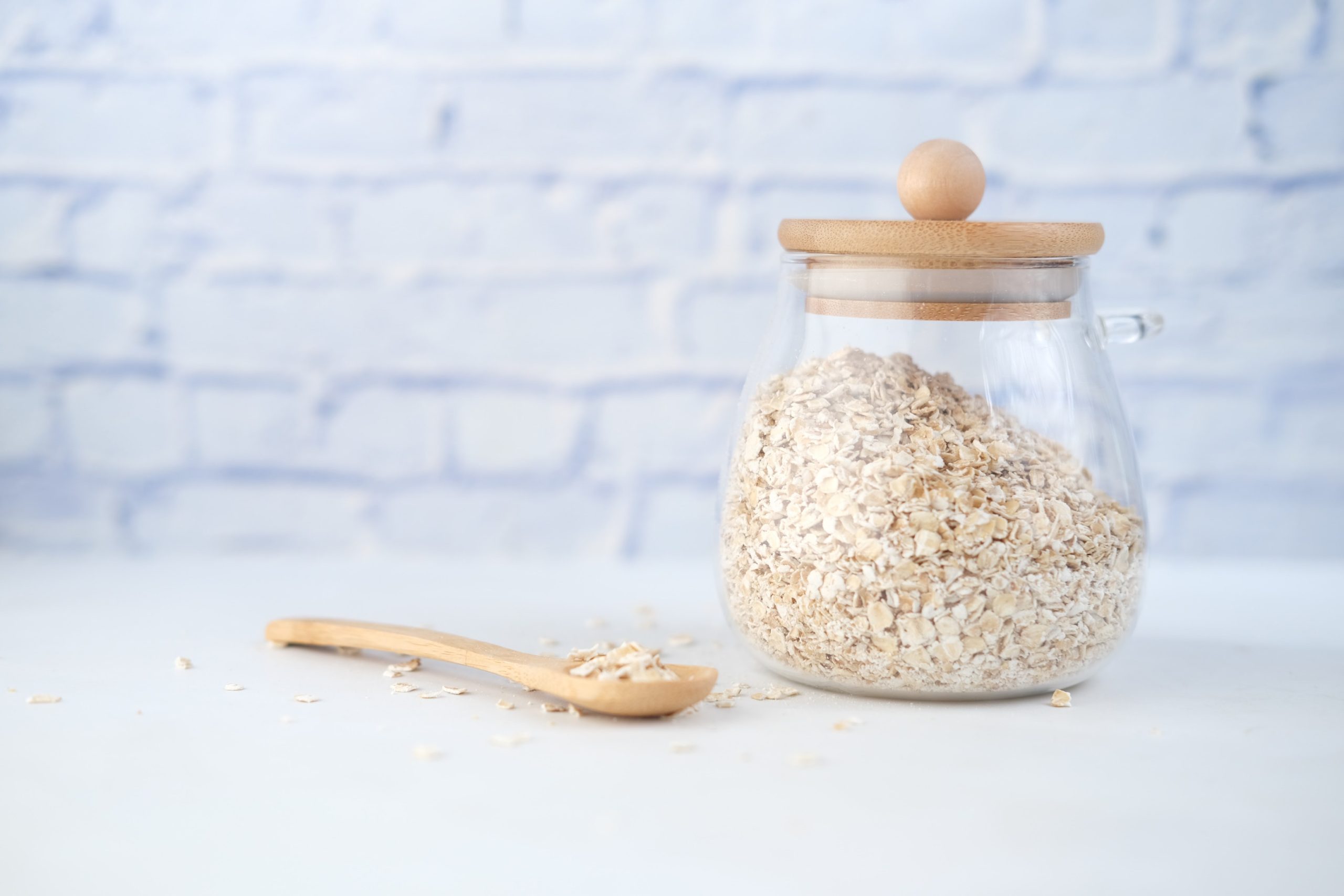 rolled oats in a jar with a wooden spoon